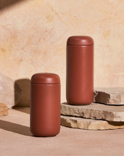 FELLOW | Carter Move Mug, Sienna / 16 oz: Two rust-colored, matte-finished travel mugs with rounded lids, designed to maintain drink flavor and temperature, ideal for on-the-go use.