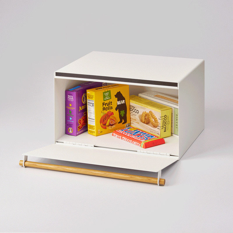 Yamazaki Home | Simple Steel Bread Box, White + Wood, showcasing a drop-down panel with assorted snacks inside, ideal for organizing and preserving kitchen essentials.