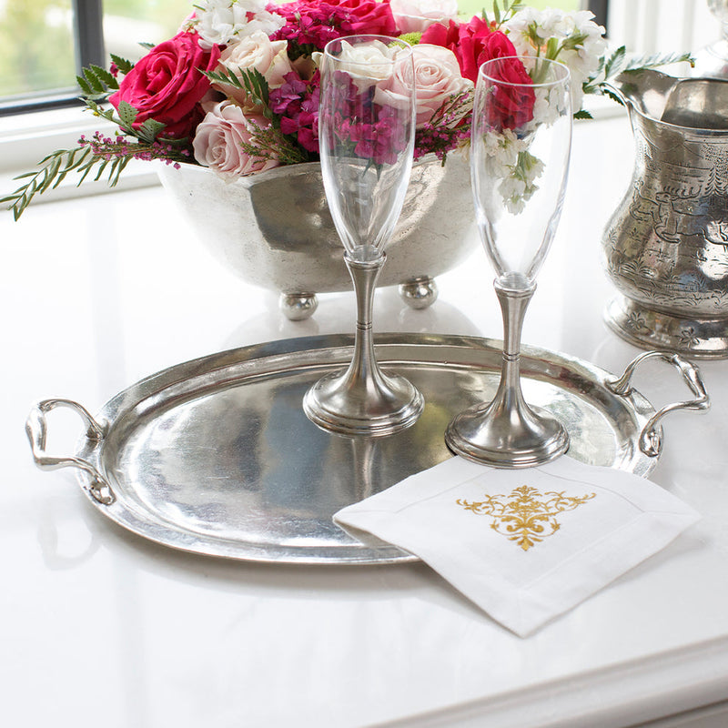Arte Italica & Crown Linen Designs | Vintage Tray with Handles featuring champagne flutes, a linen napkin, and a floral arrangement, embodying classic Italian pewter craftsmanship.