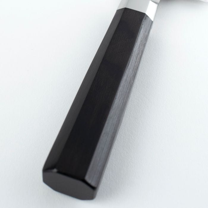Close-up of Shun Dual Core Santoku's black octagonal handle with metal ferrule, exemplifying Japanese craftsmanship for versatile kitchen cutting tasks.