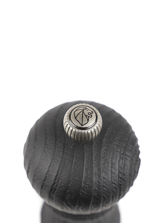 Peugeot | Paris Nature Collection Pepper Mill, Nature Black, top view showing black-stained wood with a central metal adjustment knob featuring a lion’s-head emblem, showcasing eco-friendly design.