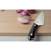 Shun | Narukami 8 Chef's Knife with polished steel blade and black handle, shown on a cutting board with shallots, exemplifies craftsmanship for professional cooks.