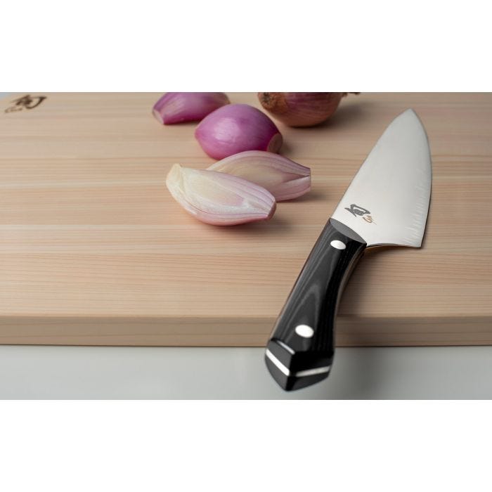 Shun | Narukami 8 Chef's Knife with polished steel blade and black handle, shown on a cutting board with shallots, exemplifies craftsmanship for professional cooks.