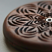 Wire Monkey | UFO Bread Journey Lame featuring a hand-carved mandala design on a wooden disc, showcasing intricate craftsmanship with a central metal eyelet.