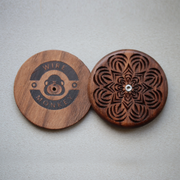 Wire Monkey UFO Bread Journey Lame halves, featuring a laser-etched logo and mandala carving, crafted from American black walnut for intricate bread scoring.