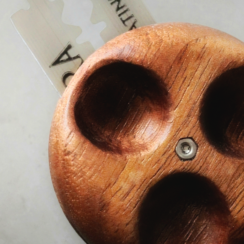 Wire Monkey | UFO NUX Lame, a thick, wooden tool with deep grooves and cup-shaped recesses, featuring a central metal fastener and razor blade element.