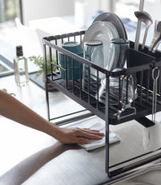 Yamazaki Home | Two-Tier Dish Rack, White, loaded with dishes, on a clean countertop. Draining spout and utensil holder visible, enhancing kitchen organization.