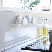 Yamazaki Home Magnetic Pot Holders, Silicone, Black, mounted on the backsplash, complement a modern kitchen setup with induction cooktop and culinary essentials.