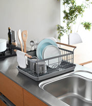 Yamazaki Home | Steel + Wood Dish Rack with Drainer Spout on countertop, featuring wooden handles, utensil holder, and plate cradle, enhancing kitchen style and function.