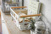 Yamazaki Home | Steel + Wood Storage Baskets, Large, holding folded linens and a cookbook, with a potted plant nearby, creating a cozy kitchen vignette.