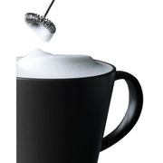 Aerolatte | Milk Frothers - Chrome beside a black mug with rich foam, showcasing its ability to froth milk for coffee drinks effortlessly.