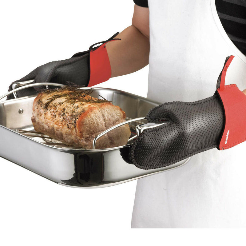Kitchen Grips | Chef's Mitt - Large - Black, shown handling a roasting pan with cooked meat, highlighting its heat protection and non-slip grip features.