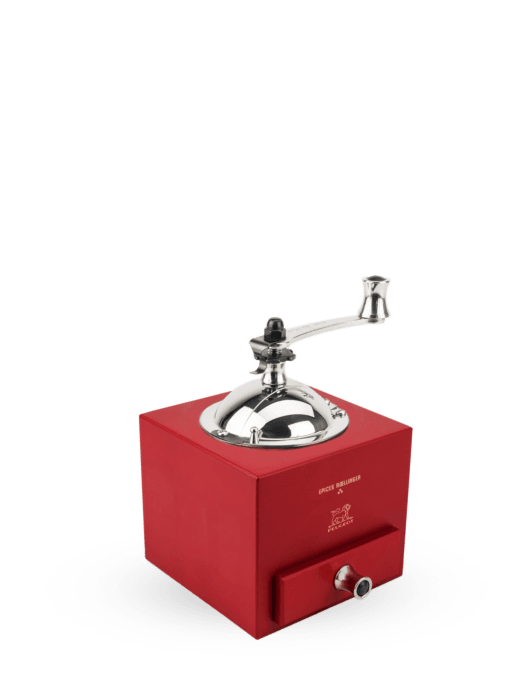 Peugeot | Roellinger Pepper Mill, 5 inches - Red: A traditional hand-crank grinder with a polished metal hopper and handle, featuring a drawer for spice collection.
