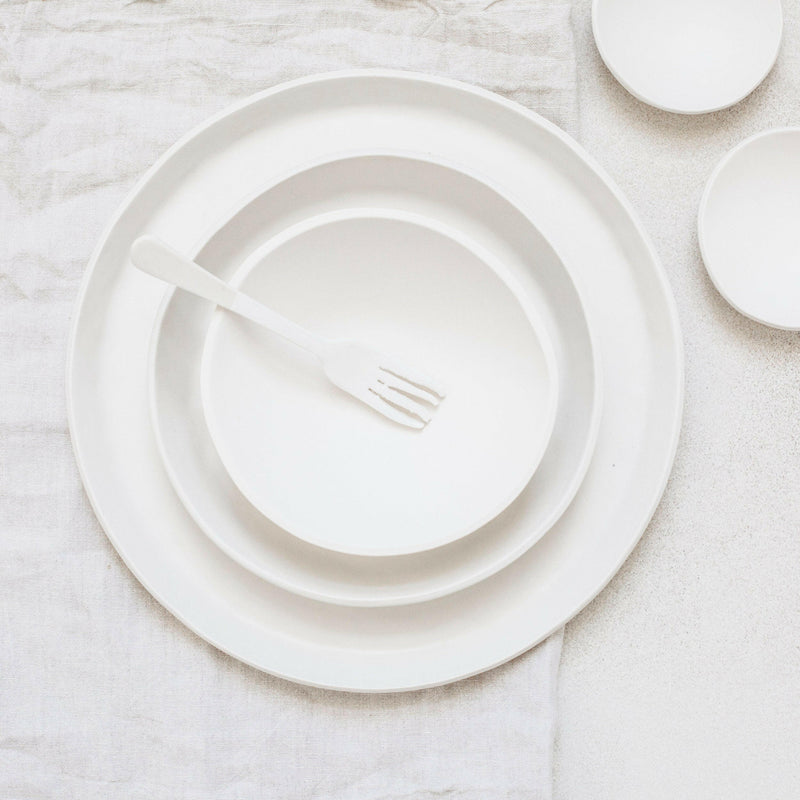 Top-down view of Looks Like White | Scandi Cereal Bowl, nested with plates, showcasing elegant simplicity and organic form, part of Trudy Crane's curated ceramics collection.