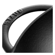 Staub Perfect Pan Wok, 14.5-inch matte black, cast iron with angled sides, glass lid, and metal rack for versatile cooking tasks like stir-frying and steaming.