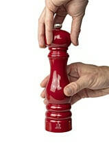 Peugeot | Paris Chef u'Select Passion Red Pepper Mill, 9 inches, is shown being twisted by two hands, highlighting its ergonomic design and precise grind adjustment feature.