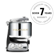 Ankarsrum stand mixer in polished chrome with a Seven Years Warranty badge, featuring a 7-liter bowl and 1500 W motor for versatile kitchen use.
