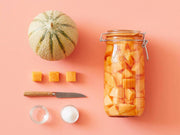 Le Parfait | Rounded French Glass Storage Jar - 3L filled with cubed cantaloupe, displayed alongside melon pieces, knife, and small containers, ideal for preserving and stylish storage.