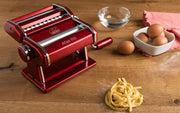 Marcato | Atlas 150 Pasta Maker on a table with pasta and eggs, showcasing its ability to create fresh, homemade pasta easily and consistently.