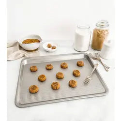 USA Pan | Cookie Tray Pans - Medium, featuring an innovative scoop design, easy-grip handle, tapered edge, and Americoat nonstick coating for effortless baking and cleanup.