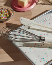 GIR Baking Mat - Sprinkles - 12 x 17 on a tray with a whisk and spatula, ideal for versatile baking tasks.