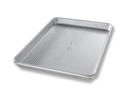 USA Pan Jelly Roll Pan with corrugated design and reinforced rims, ideal for baking rolls, cookies, and sheet cakes; features nonstick coating for easy cleanup.