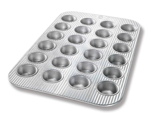 Mini muffin pan with 24 cavities, crafted from heavy-gauge aluminized steel, featuring Americoat nonstick coating for easy release and cleanup. Ideal for baking bite-sized treats.