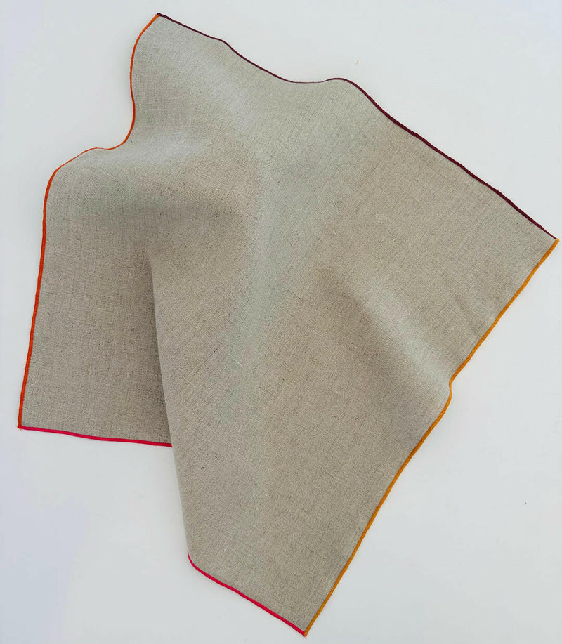Tisch New York | Natural Linen Napkins Set of 4 - Pink Hem, featuring beige fabric with a red-edged design, ideal for elegant dining settings.