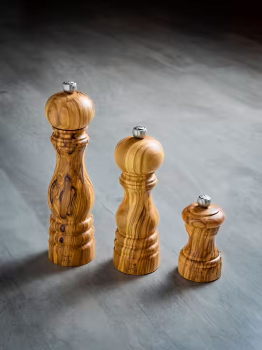 Three Peugeot Paris Classic Olive Wood Mills, 9-inch, with metal knobs, showcasing elegant craftsmanship and sustainable design for seasoning with precision.