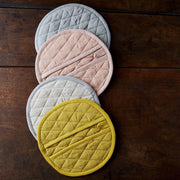 Sir|Madam Linen Pot Holder - Single - Salmon: A circular, pocketed linen mitt, versatile for kitchen use and as a dining room trivet, enhancing kitchen aesthetics.