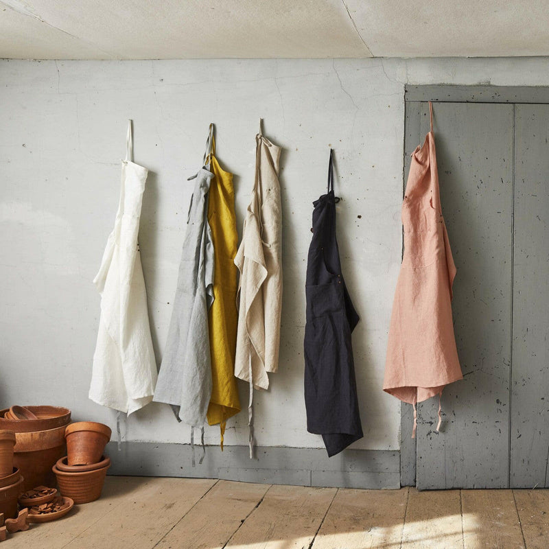 Linen Grand Apron by Sir|Madam on hanger, showcasing adjustable neck loop and side-vents for pocket access, emphasizing functionality for kitchen enthusiasts.