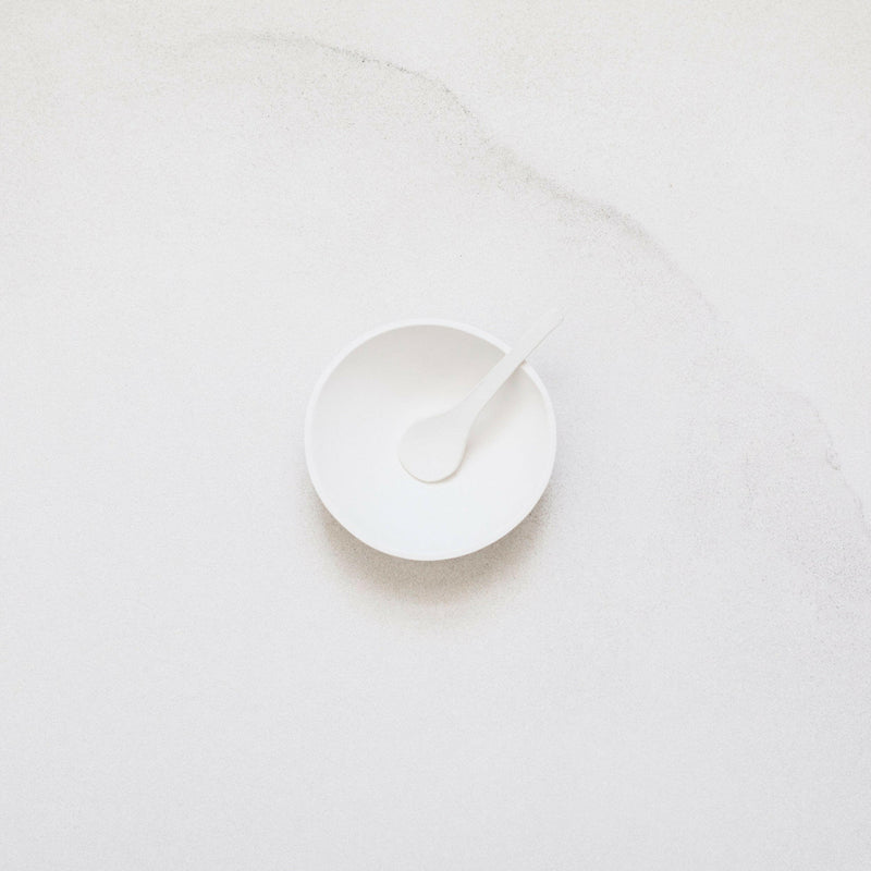 Looks Like White | Scandi Cereal Bowl with matching spoon, showcasing minimalist design and organic form on a marble-like surface, crafted by artist Trudy Crane.
