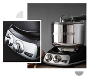 Ankarsrum Assistent Original stand mixer with stainless-steel bowl and chrome dials on black base, ideal for versatile baking and cooking needs.
