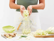 Le Parfait 3L glass jar used for fermenting cabbage, surrounded by cabbage, ginger, and bay leaves, showcasing versatile kitchen storage from Athens Cooks.