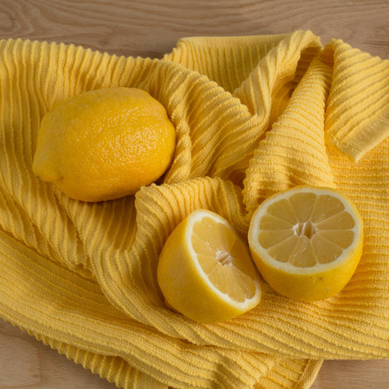 Danica | Ripple Dishtowel - London Gray displayed with a halved lemon, highlighting its kitchen utility and absorbency, perfect for enhancing culinary experiences.