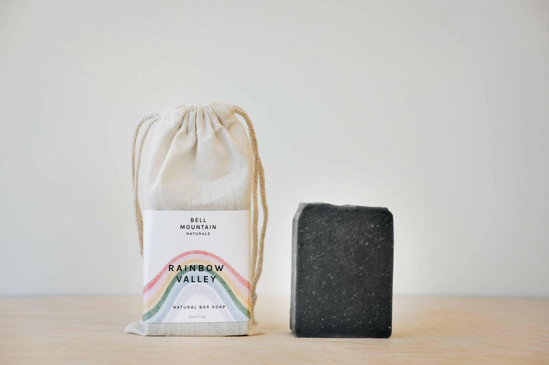 Bell Mountain | Bar Soaps - Solstice, featuring a bar of soap with a rainbow design, accompanied by a matching white bag with a rainbow label.