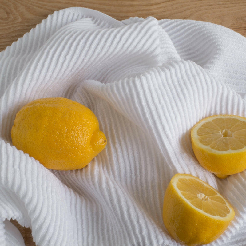 Danica | Ripple Dishtowel - London Gray displayed with fresh lemons, highlighting its kitchen utility and absorbency, perfect for enhancing your culinary experience.